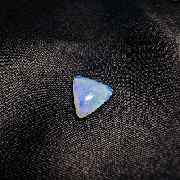 Cabujón triángular de ópalo australiano. El arco iris en piedra.