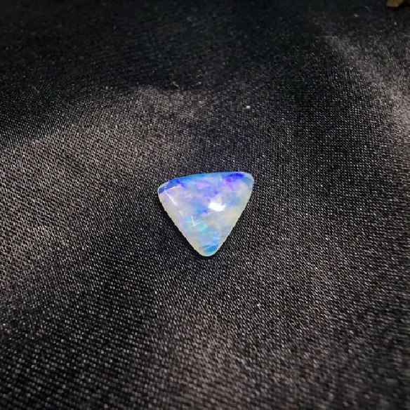 Cabujón triángular de ópalo australiano. El arco iris en piedra.