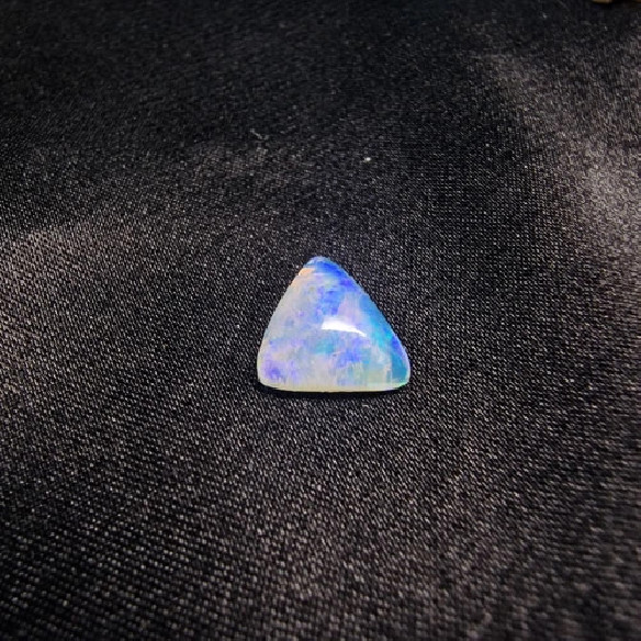 Cabujón triángular de ópalo australiano. El arco iris en piedra.