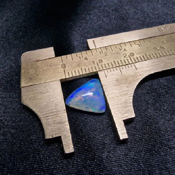 Cabujón triángular de ópalo australiano. El arco iris en piedra.
