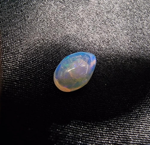 Cabochão gota de opala australiana. O arco-íris em pedra.