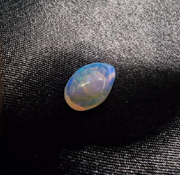 Cabochão gota de opala australiana. O arco-íris em pedra.