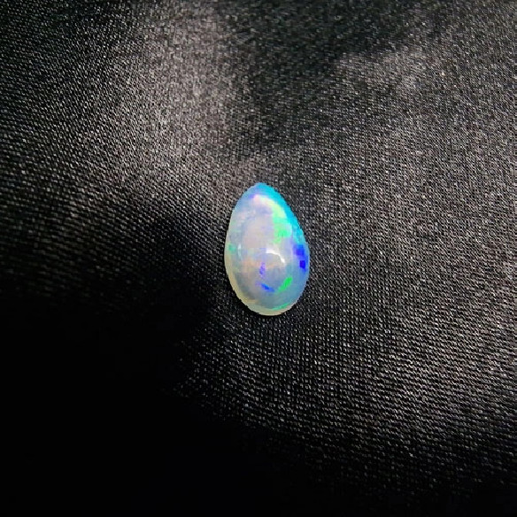 Cabochão gota de opala australiana. O arco-íris em pedra.
