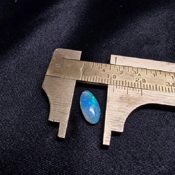 Cabujón oval de ópalo australiano. El arco iris en piedra.