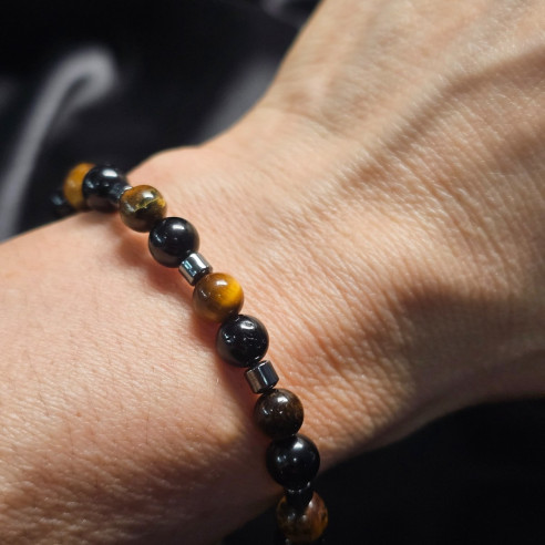 Pulsera de minerales protectores colocada en la muñeca: ojo de tigre, turmalina negra y hematite. Contra mal de ojo y envidias