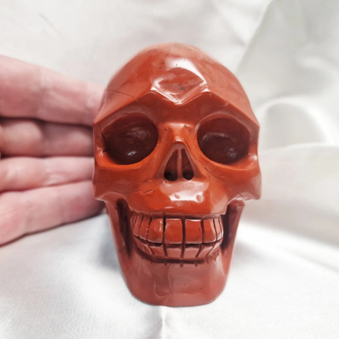 Figura de caveira de jaspe vermelho. A caveira evoca memória