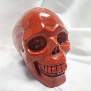 Figura de caveira de jaspe vermelho. A caveira evoca memória