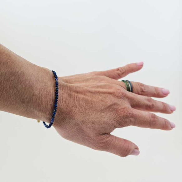 3mm faceted lapis lazuli bracelet with vermeil clasp worn on wrist.